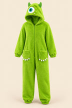A person wearing a bright lime green monster onesie stands in a kitchen in front of an open refrigerator. The hood has a large eye detail, and the legs have small white teeth accents.