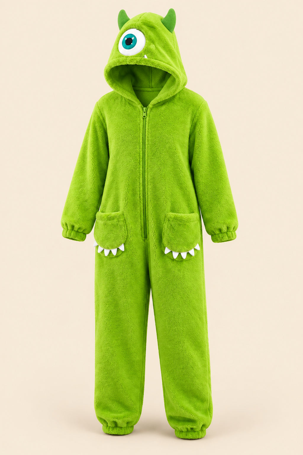 A person wearing a bright lime green monster onesie stands in a kitchen in front of an open refrigerator. The hood has a large eye detail, and the legs have small white teeth accents.