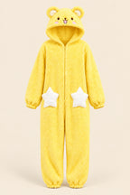 A person wearing a fluffy yellow bear-themed hooded onesie with white star patches on the legs, taking a mirror selfie in a bedroom setting.