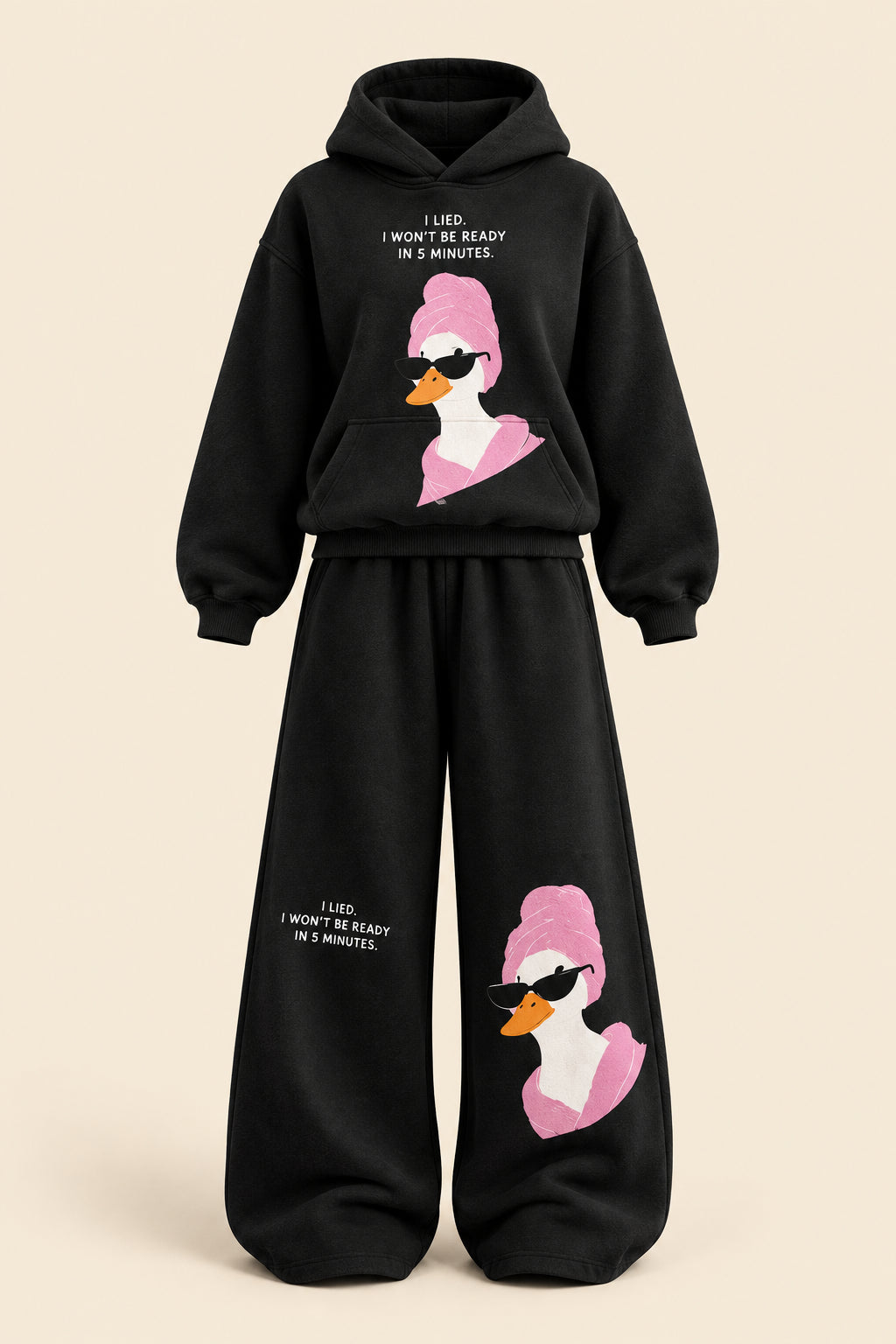 A woman modeling a black two-piece lounge set with a pink and white duck graphic and white text, standing in a room with a dark paneled wall and gray floor. The image includes 'Rose home wear' branding and a pink 'ROSE' banner on the left.