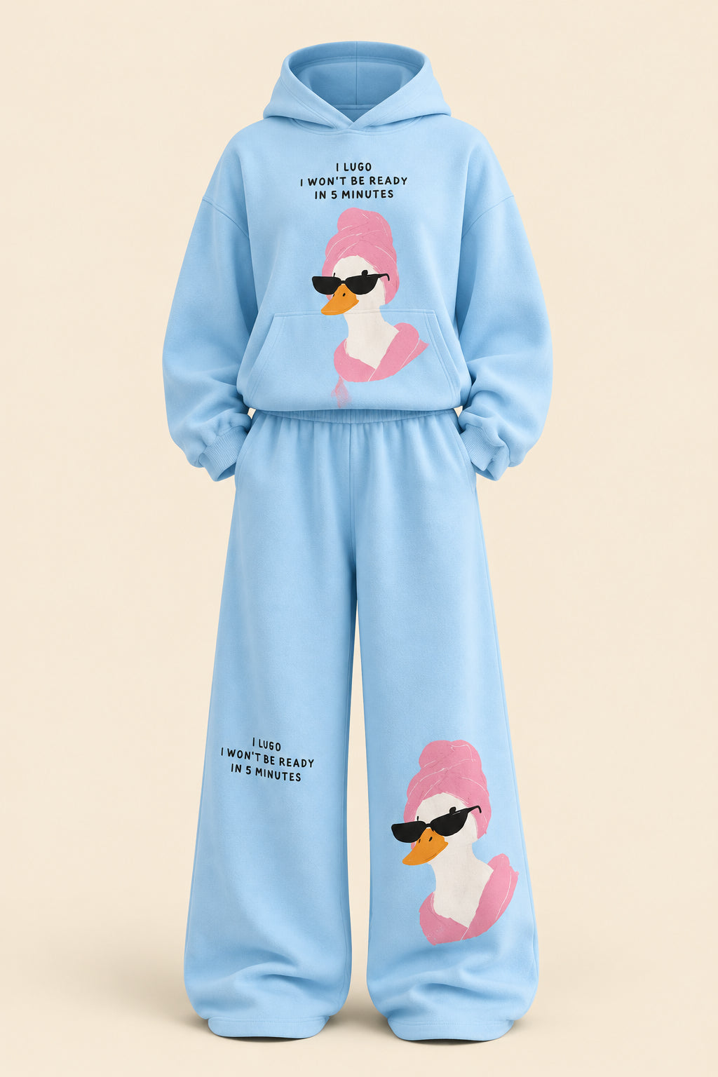 A woman modeling a light blue two-piece loungewear set with a cartoon duck graphic and text, standing in an indoor room with a dark paneled wall and gray floor. Brand text 'Rose home wear' and 'ROSE' appear as overlays.