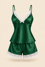 A woman models a two-piece satin pajama set in forest green with white lace trim, featuring a camisole top and matching shorts. The image includes an inset of the model wearing the set, a brand logo 'ASAAL Designs' in the top right, and a code label 'Code 229' in the bottom right.