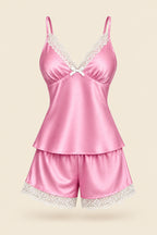 A woman models a pink satin lingerie set with white lace trim, featuring a camisole top and matching shorts. The image includes an inset showing the full-length view, an 'ASAAL Lingerie' brand logo, a product code label, and a vertical barcode.