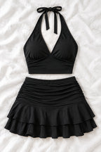 A woman modeling a black two-piece outfit consisting of a halter crop top and a ruched ruffled mini skirt, shown in front and back views side by side. The image has a pink 'Diva shop' logo at the top and contact details at the bottom.