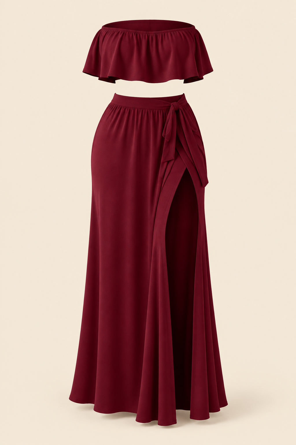 A woman modeling a burgundy two-piece lingerie set in a luxurious indoor setting. The set includes a strapless ruffled crop top and a matching high-slit maxi skirt.
