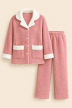 A pink fleece pajama set with white sherpa lining, including a long-sleeve button-front top and matching pants, displayed on a white background with a small cup prop and a visible HL logo in the top left.